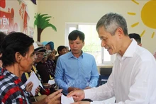 El embajador Nguyen Minh Vu entrega regalos a los vietnamitas desfavorecidos en la provincia de Siem Reap. (Foto: VNA)
