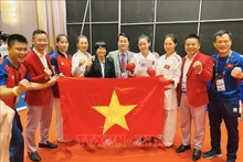 La alegría de las atletas y la junta de entrenamiento de la selección vietnamita de Kárate cuando ganaron la medalla de oro en la modalidad femenina de kumite por equipo. (Foto: hanoimoi.com.vn)