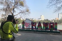 Turistas extranjeros en el lago Hoan Kiem, en Hanói (Foto: daidoanket.vn)
