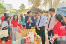 Los delegados visitan un stand que exhibe las máquinas y equipos para preparar café en la feria (Foto: qdnd.vn)