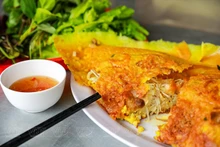 El banh xeo se sirve con verduras frescas cultivadas en los huertos locales. La salsa de pescado está mezclada por expertos, con un equilibrio armonioso de sal, acidez, dulzura y un toque de ajo y picante. (Foto:VNP)