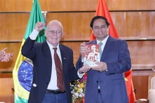 El secretario general de la Asociación de Amistad Brasil-Vietnam, Pedro de Oliveira, entrega al primer ministro Pham Minh Chinh el libro "Ho Chi Minh Vida e obra do lisder da lisder da libertação nacional do Vietnã" (Ho Chi Minh, la vida y obra del líder de la liberación nacional de Vietnam). (Foto: VNA)