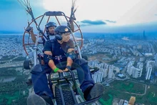 Turistas contemplan Ciudad Ho Chi Minh desde las alturas con parapentes