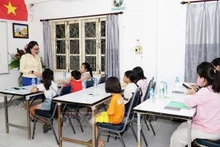 Una clase del idioma vietnamita para niños vietnamitas en Laos. (Foto: VNA)