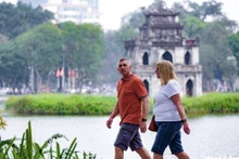 Turistas extranjeros pasean por el lago Hoan Kiem, en Hanoi (Foto: tuoitre.vn)
