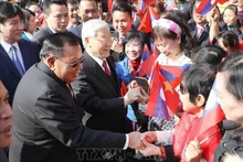El secretario general del PCV, Nguyen Phu Trong, y el secretario general del Partido Popular Revolucionario y presidente de Laos, Bounnhang Vorachith, con el pueblo de Hanói, el 19 de diciembre de 2017. (Foto: VNA)