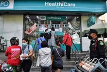 La gente hace cola para comprar pruebas subvencionadas de antígeno rápido (ATK) del Covid-19 en una farmacia de la Organización Farmacéutica del Gobierno en Bangkok en enero de 2022. (Foto: AFP/VNA)