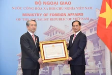 El viceprimer ministro y ministro de Relaciones Exteriores de Vietnam, Bui Thanh Son (derecha), entrega la Orden de la Amistad al embajador chino, Xiong Bo. (Foto: VNA)