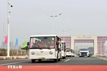 Los vehículos eléctricos que transportan a los turistas pasan por la línea divisoria del puente Bac Luan II (Foto: VNA)