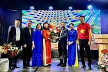 Chu Tuan Duc, consejero de la embajada de Vietnam en Alemania, entrega flores a Bui Thi Thu Minh, nueva jefa de Comité de Enlace para los vietnamitas residentes en Europa “Por el mar y las islas de Vietnam”. (Foto: VNA)
