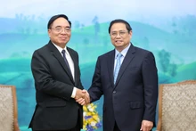 El primer ministro Pham Minh Chinh recibe al ministro de Planificación e Inversión de Laos, Khamchen Vongphosy. (Foto: VNA)