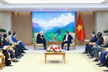 El primer ministro Pham Minh Chinh (centro, derecha) y Thomas Vallely, presidente del consejo directivo de la Universidad Fulbright de Vietnam, en su reunión en Hanói el 17 de julio. (Foto: VNA)
