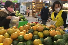 Pobladores compran productos expuestos en Big C Thang Long (Fotografía: VNA)