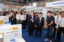 Las autoridades de Binh Duong y los participantes visitan las exposiciones (Foto: VNA)