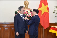 El ministro vietnamita de Relaciones Exteriores, Bui Thanh Son, entrega la medalla conmemorativa “Por la causa de la diplomacia vietnamita” al embajador japonés en Vietnam, Yamada Takio. (Foto: TGVN)