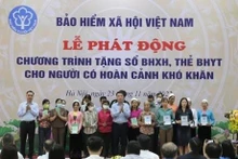 Dirigentes del Seguridad Social de Vietnam entregan libretas de seguro social y médico a personas en circunstancias difíciles.