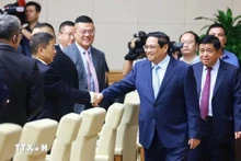 El primer ministro de Vietnam, Pham Minh Chinh (en la derecha), estrecha la mano de empresario chino. (Fotografía: VNA)
