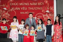 Entrega de libros en idioma vietnamita a niños coterráneos. (Fotografía: VNA)