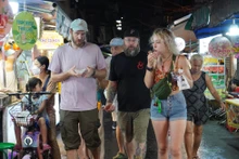Turistas extranjeros disfrutan de la gastronomía nocturna en Ciudad Ho Chi Minh.