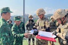 Los comandantes de patrulla de los guardias fronterizos de la provincia de Lao Cai y su homólogo chino de Mengzi firman un registro de patrulla bilateral en 2023. (Fotografía: bienphong.com.vn)