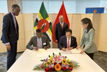 El canciller vietnamita, Bui Thanh Son, y el ministro de Relaciones Exteriores, Negocios Internacionales, Comercio y Energía de la Mancomunidad de Dominica, Vince Henderson, firman un acuerdo de exención de visa para titulares de pasaportes diplomáticos y oficiales. (Fotografía: VNA)