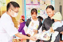 El personal médico de la comuna de Muong Cai, distrito de Song Ma, provincia de Son La, distribuye entre la población folletos propagandísticos sobre la planificación familiar. (Fotografía: Nhan Dan)