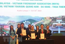 Representantes vietnamitas y malayos firman un memorando de entendimiento sobre cooperación en comunicación y promoción turística. (Fotografía: VNA)