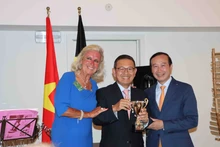 El embajador Nguyen Van Thao y Chris Geykens entregan trofeo de recuerdo al golfista aficionado. (Fotografía: VNA)