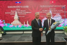 El presidente de la Asociación de Amistad Vietnam-Laos, Ngo Minh Chau, entrega flores para el cónsul laosiano en Ciudad Ho Chi Minh, Phonesy Bounmixay, con motivo del Día Nacional de Laos.