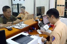 Las personas realizan trámites para revocar la placa en el Departamento de Policía de Tránsito de Hanói. (Fotografía:VNA)