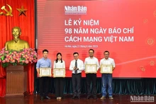 El director-editor del diario, Le Quoc Minh, entrega certificado de mérito a los individuos destados en 2022.
