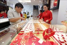 La gente acude a las tiendas para comprar oro en el Día del Dios de la Riqueza. (Fotografía: VNA)
