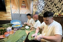 El dueño del restaurante Pho Quyet en Tokio, Dang Huy Quyet, y sus empleos preparan obsequios. (Fotografía: VNA)
