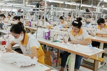 Una línea de costura y bordado en Vietnam para la exportación. (Fotografía: VNA)