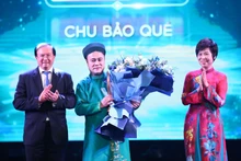 La directora general de la VNA, Vu Viet Trang (derecha), y el viceministro de Cultura, Deportes y Turismo, Ta Quang Dong (izquierda), entregan el premio de Artista inspirador a Chu Bao Que. (Foto: VNA)