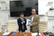 Vo Van Be, subdirector y subeditor en jefe de la Editorial Política Nacional Su That, regala el libro a Rogelio Polanco Fuentes, jefe del Departamento Ideológico en el Comité Central del Partido Comunista de Cuba. (Fuente:VNA)