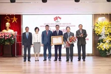 El viceministro permanente de Relaciones Exteriores de la nación indochina, Nguyen Minh Vu entrega a la Asociación de Amistad Vietnam - Singapur el Certificado de Mérito del primer ministro (Fuente: VNA)