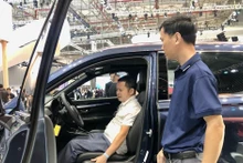 Visitantes experimentan modelos de automóviles aplicados nuevas tecnologías en la exposición. (Fuente:VNA)