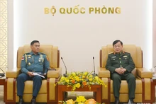 El coronel general Hoang Xuan Chien (D), viceministro vietnamita de Defensa, recibe al agregado militar de Indonesia, Jerry Henry Manuhutu.