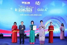 Nguyen Duc Loi, vicepresidente permanente de la Asociación de Periodistas de Vietnam y Vu Viet Trang, directora general de la Agencia de Noticias de Vietnam, entregaron el premio A al autor. (Fuente: VNA)