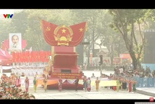 Caravana con el modelo del Escudo Nacional de la República Socialista de Vietnam desfilando frente a la tribuna. (Foto: VNA)