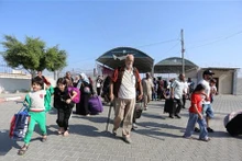 Las personas salen de la Franja de Gaza a través del paso fronterizo de Rafah hacia Egipto. (Fuente: Xinhua/VNA)