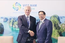 El primer ministro Pham Minh Chinh (derecha) y el director ejecutivo del grupo Standard Chartered Bill Winters. (Foto: VNA)