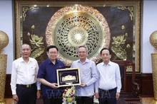 El presidente de la Asamblea Nacional, Vuong Dinh Hue, regala un obsequio al Comité del Partido Comunista de Vietnam en Bac Lieu. (Foto: VNA)