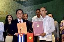 Nguyen Trong Nghia y Rogelio Polanco Fuentes firman un acuerdo de cooperación entre sus respectivos órganos (Fuente: VNA)