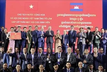 El presidente To Lam (octavo desde la izquierda, tercera fila) y exestudiantes camboyanos graduados en Vietnam (Foto: VNA)