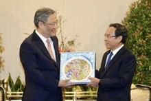 Wang Wentao regala a Nguyen Van Nen un cuadro cerámico que simboliza la amistad de los dos países, con las flores nacionales de los dos países, la peonía y el loto (Fuente: VNA)