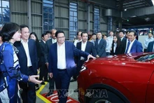 El primer ministro de Vietnam, Pham Minh Chinh, aprecia los modelos de carros fabricados en el país de Ford (Foto: VNA)