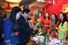 El primer ministro Pham Minh Chinh y su esposa visitan un puesto de productos del Tet en Polonia. (Foto: Nhan Dan)