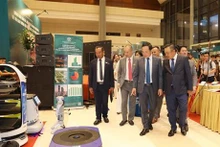 El viceprimer ministro Tran Luu Quang y líderes de Hanói visitan el espacio de promoción comercial. (Foto: VNA)